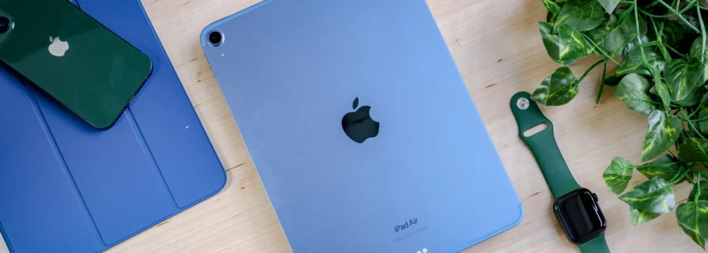 New Apple iPad Air 6 (2024) in blue resting on table next to Smart Watch and iPhone