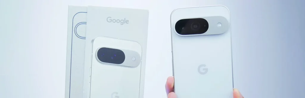 Hand holds white Google Pixel 9 mobile phone and packaging 